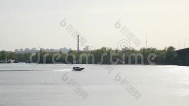 <strong>快速</strong>摩托艇<strong>快速</strong>地在河上向桥上漂浮。 工业城市的背景。